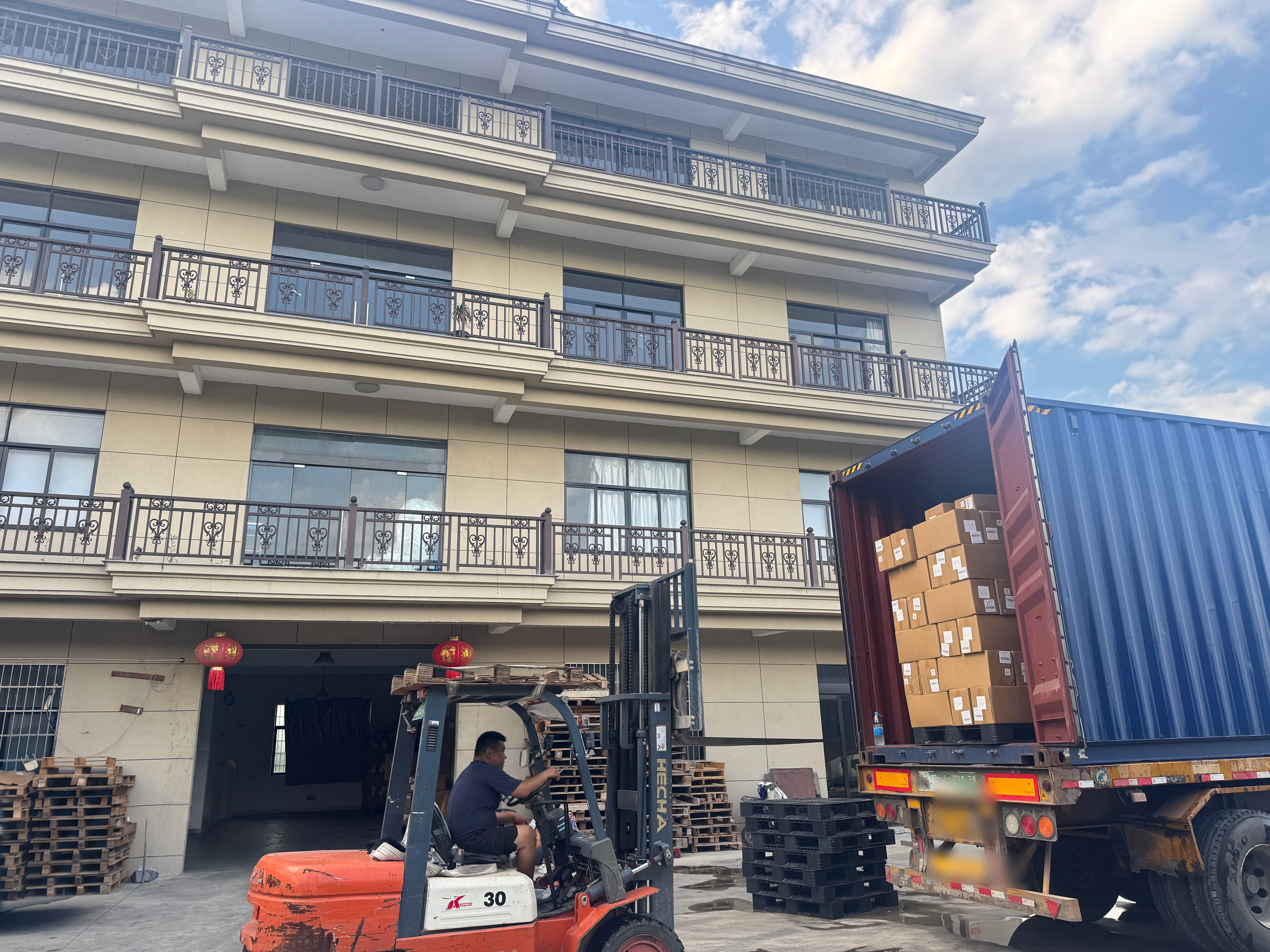 Forklift moving export cartons into a shipping container